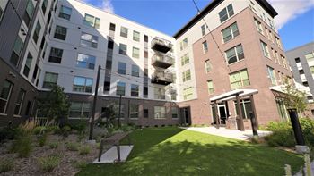 a grassy courtyard in front of an apartment building